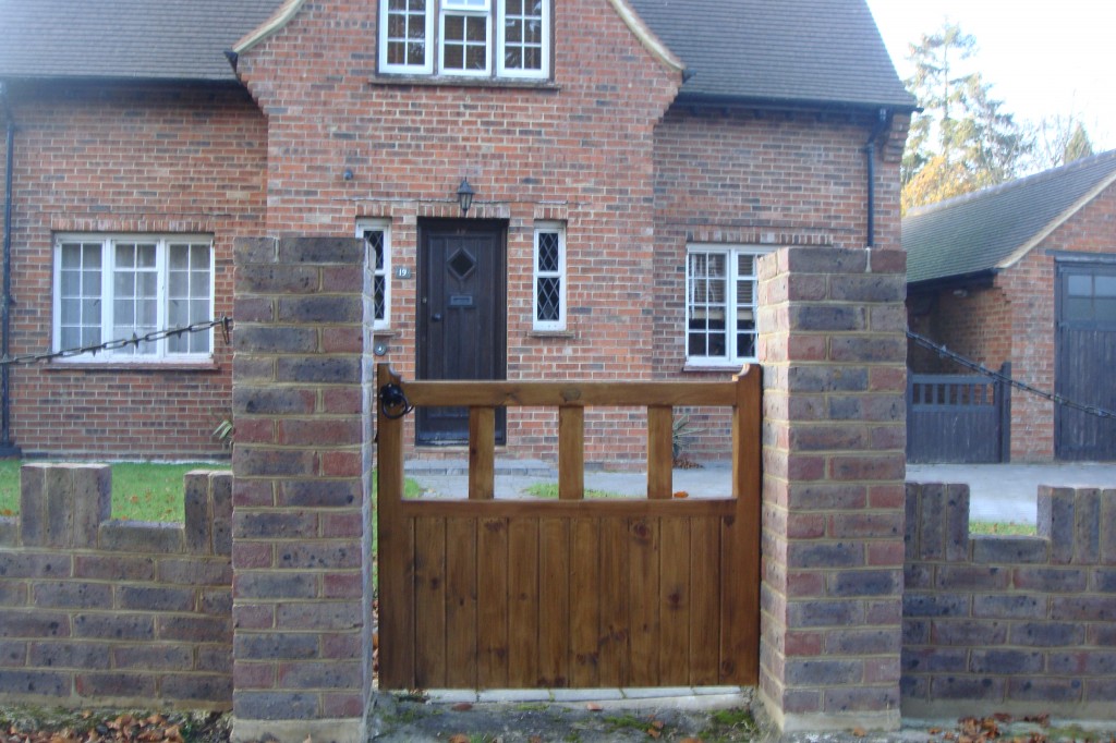 Brick front garden wall with piers and a timber gate