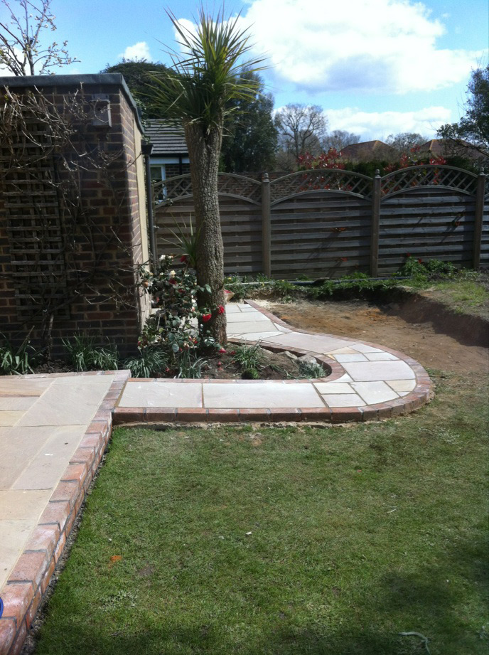 Curved garden path with brick edging and a lawn